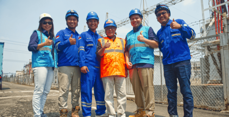 Energy workers posing in front of electric lines in Jakarta, Indonesia